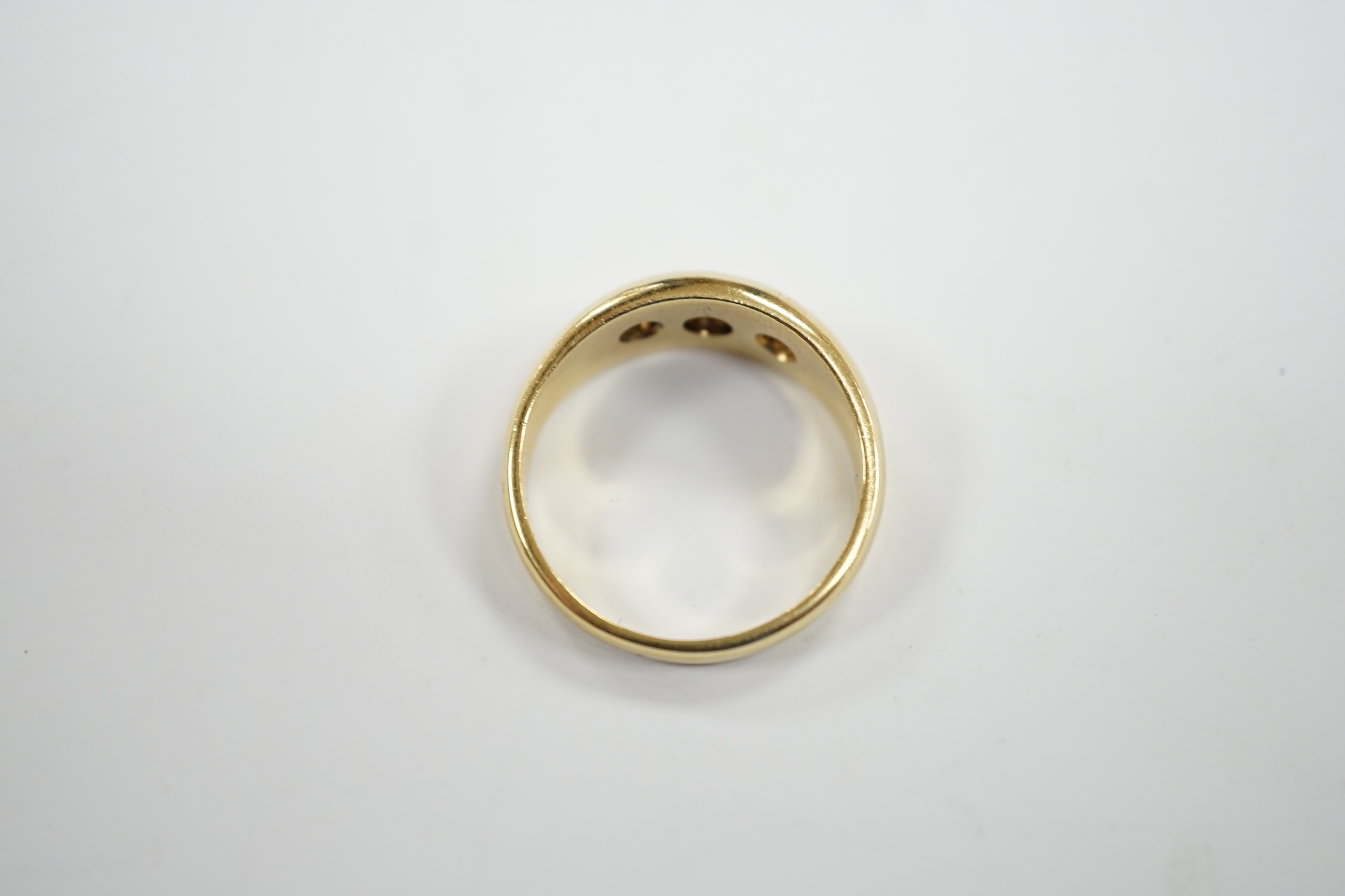 A modern 18ct gold and gypsy set three stone diamond ring, size S, gross weight 7.9 grams.